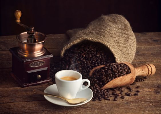 Kaffeemühle mit Espressotasse Kaffeesack mit Kaffeebohnen auf Holzbrett